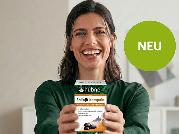 Frau hält Packshot mit hübner Shilajit in der Hand
